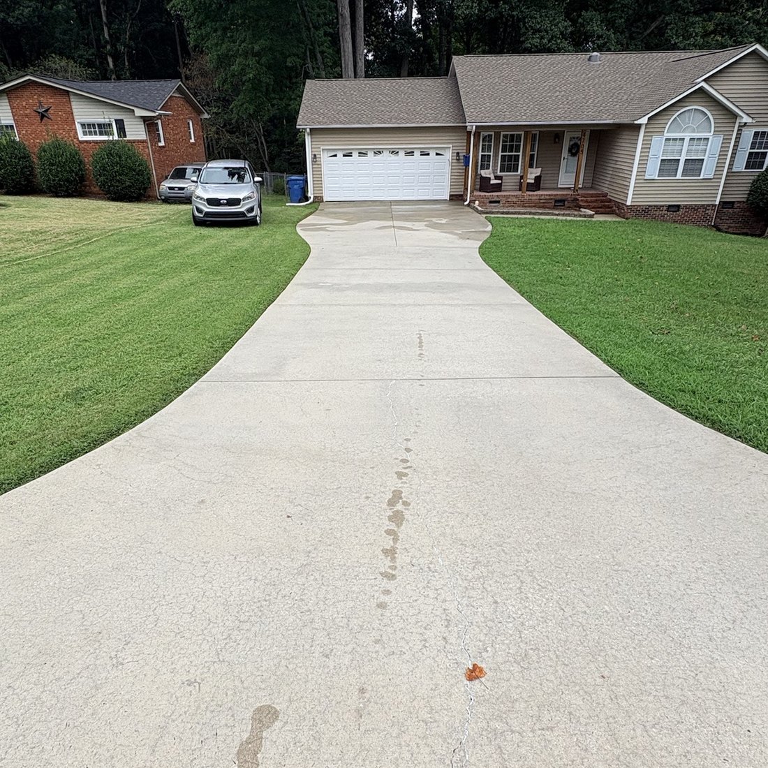 Concrete driveway after pressure washing, the surface an even clean light grey